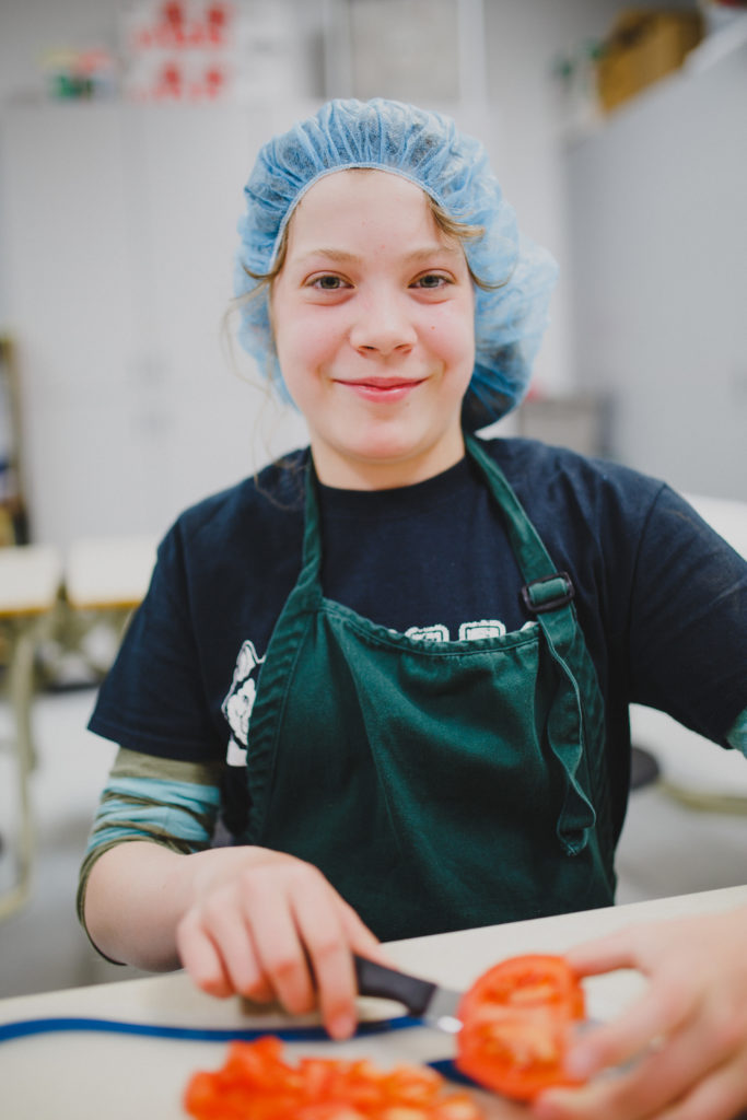 girl cutting tomato